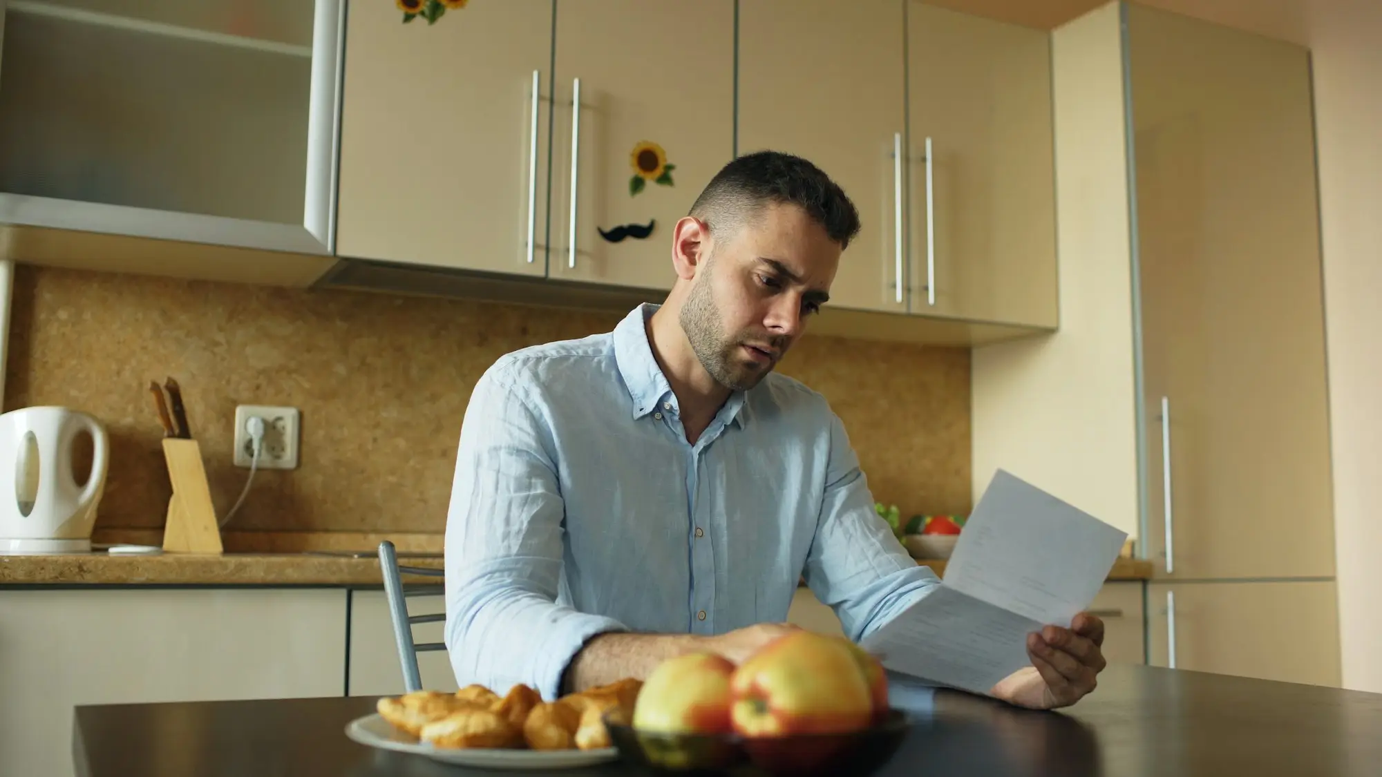 Business owner reading a letter at the kitchen table