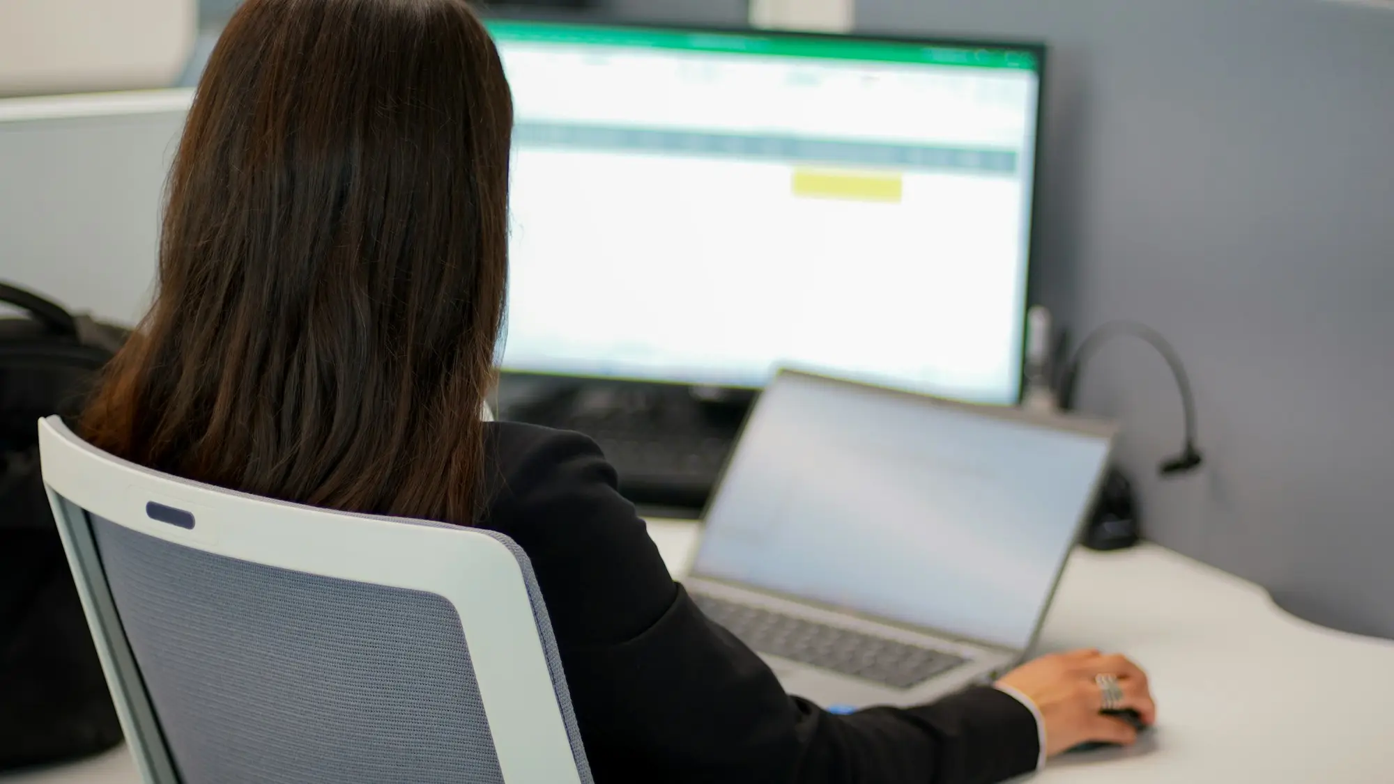 Person working on a laptop at a home office desk