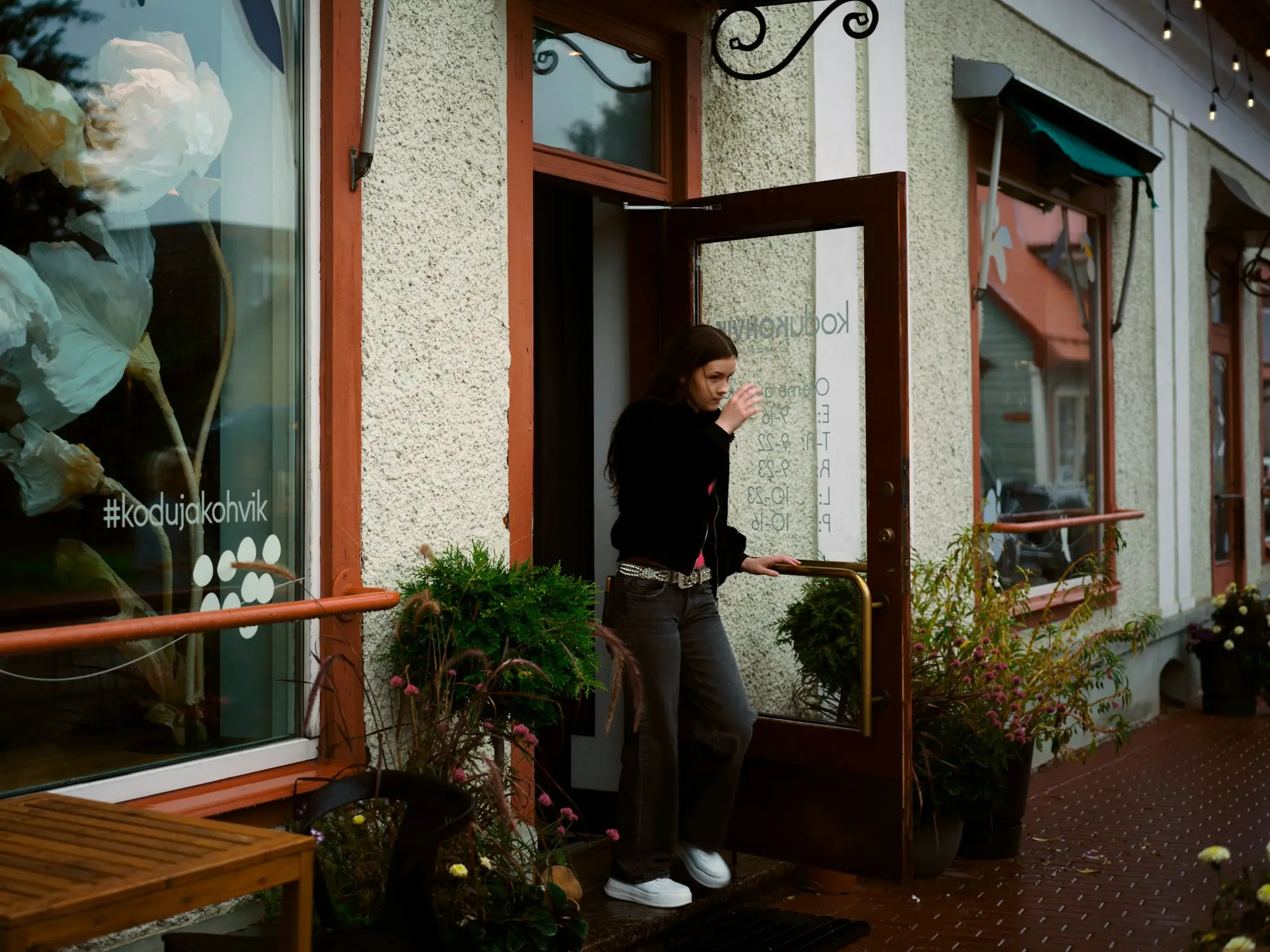 New business owner stepping out of her shopfront doorway